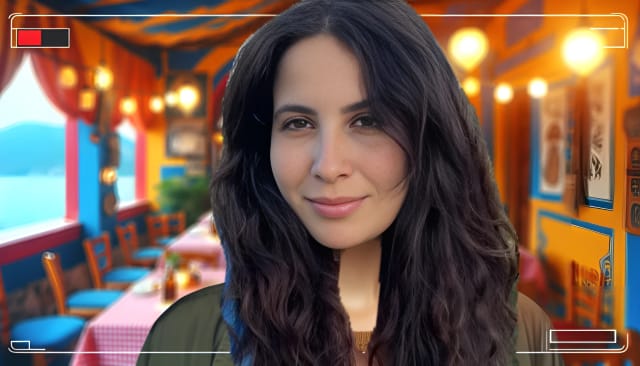 Chryssanthi Kavazi, a talented actress with fair skin and long, wavy hair, looking into the camera with a gentle and relaxed expression. She is in a Greek restaurant, surrounded by traditional decorations and warm lighting, reflecting her Greek heritage. Vibrant colors and high-resolution details make the image captivating.